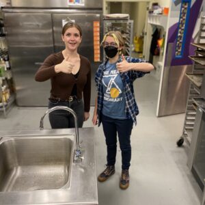 two baristas giving thumbs up gesture