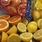 spread out cara cara oranges and lemons on a stainless counter